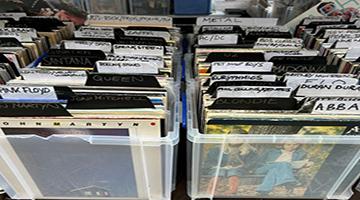 White plastic storage tubs with labelled vinyl records