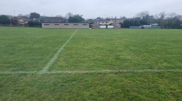 Sports pitch with houses in the background