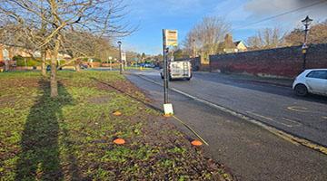 Photo of a bus stop next to a field and main road